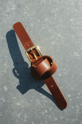 Galveston Heritage Leather Belt in figure-eight knot on galvanized metal background